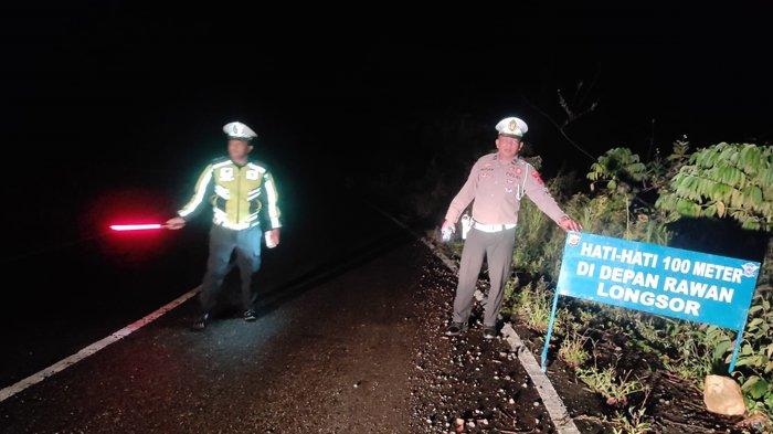 Seorang personel Satlantas Polres Pidie memandu satu kendaraan melewati jalan ambruk di Km 11 Geumpang, Pidie, Rabu (2/11/2022) supaya terhindar dari kecelakaan lalu-lintas.