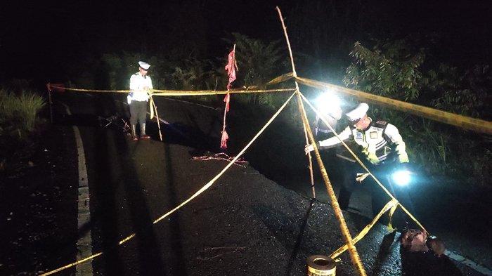 Personel Satlantas Polres Pidie memasang rambu di lokasi jalan ambruk di Km 11 Geumpang, Pidie, Rabu (2/11/2022) supaya terhindar dari kecelakaan lalu-lintas.