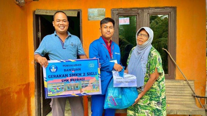 Penyerahan bantuan secara kepada seorang korban banjir di Aceh Tamiang dari SMKN 2 Sigli.