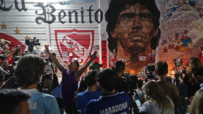 Para Fans tim sepak bola Argentinos Juniors mendatangi dan memberi ucapan belasungkawa kepada mendiang Diego Armando Maradona di altar Stadion Diego Armando Maradona Argentinos Juniors di lingkungan La Paternal, Buenos Aires, pada 25 November 2020, tepat di hari kematiannya.