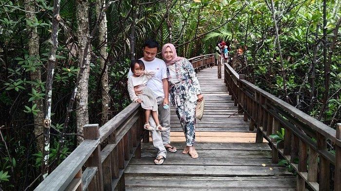 Jalur pejalan kaki menjadi objek berfoto di ekowisata hutan mangrove yang dikelola Badan Usaha Milik Kampong (BUMK) Bina Cita Kreasi Gosong Telaga Selatan, Kecamatan Singkil Utara, Aceh Singkil, Minggu (10/1/2021).