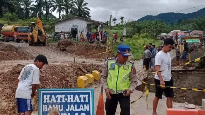 Petugas kepolisian Polres Pakpak Bharat memantau upaya perbaikan lokasi jalan nasional yang amblas di Desa Sibande, Kecamatan Sitellu Tali Urang Jehe, Kabupaten Pakpak Bharat. Jalur ini penghubung Sumut ke Kota Subulussalam atau Aceh wilayah Barat Selatan.