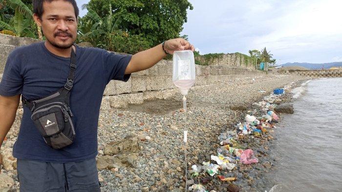 Ario Tri Yudha relawan Ekspedisi Sungai Nusantara, memungut limbah Medis di Pantai Tawiri Kota Ambon, Kamis sore (17/11)