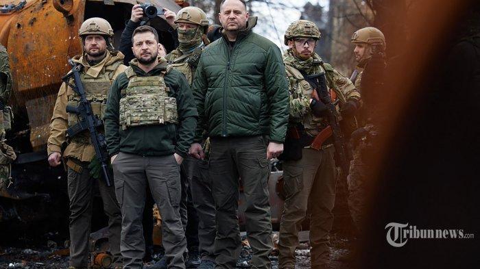 Sebuah gambar selebaran yang diambil dan dirilis pada 4 April 2022 oleh layanan pers kepresidenan Ukraina menunjukkan Presiden Ukraina Volodymyr Zelensky (kedua kiri) mengunjungi kota Bucha, barat laut ibukota Ukraina, Kyiv. - Presiden Ukraina Volodymyr Zelensky mengatakan pada 3 April 2022 bahwa kepemimpinan Rusia bertanggung jawab atas pembunuhan warga sipil di Bucha, di luar Kyiv, di mana mayat-mayat ditemukan tergeletak di jalan setelah kota itu direbut kembali oleh tentara Ukraina. Kementerian Pertahanan Rusia menolak tuduhan pada hari yang sama dengan alasan bahwa pasukan Rusia meninggalkan Bucha pada 30 Maret sementara bukti pembunuhan disajikan empat hari kemudian. (Photo by UKRAINIAN PRESIDENTIAL PRESS SERVICE / AFP)