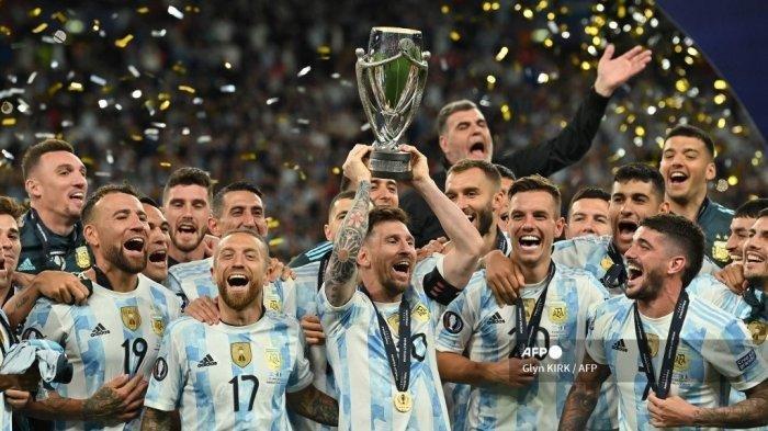 Striker Argentina Lionel Messi mengangkat trofi saat para pemain Argentina merayakan di lapangan setelah kemenangan mereka dalam pertandingan persahabatan internasional 'Finalsima' antara Italia dan Argentina di Stadion Wembley di London pada 1 Juni 2022. Azzurri menghadapi juara kontinental Amerika Selatan di Finalissima perdana di Wembley.