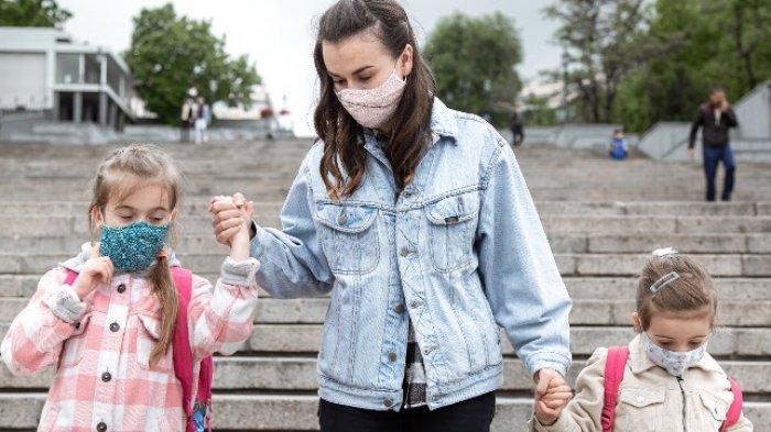Anak-anak menuju ke sekolah bersama orang tuanya.
