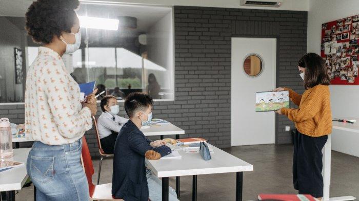 Anak-anak dan guru melaksanakan kegiatan belajar mengajar.