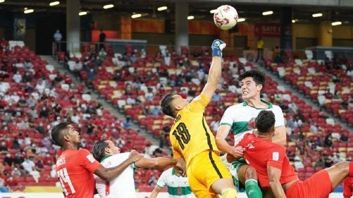Bek Timnas Indonesia Elkan Baggott (kanan atas) coba menyundul bola dalam semifinal leg pertama Piala AFF 2020 melawan Singapura, Rabu (22/12/2021), di Stadion Nasional, Kallang, Singapura.