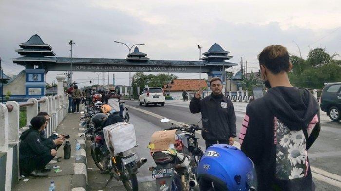 Kendaraan pemudik berbaris di bahu jalan depan Gapura Selamat Datang Kota Tegal, Sabtu (30/4/2022), pagi hari. Mereka mengabadikan momen untuk berfoto.