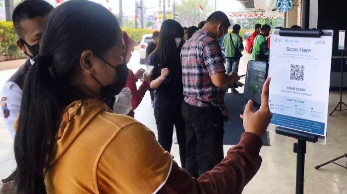 Satu di antara pengujung pusat perbelanjaan di Kota Semarang, mengenakan masker dan melakukan scanning barcode PeduliLindungi sebelum memasuki pusat perbelanjaan, Rabu (18/5/2022).