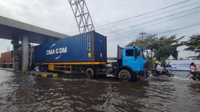 Sopir truk kontainer Mbah Gober dan beberapa truk lainnya pilih tak terjang air rob untuk memberikan kesempatan karyawan pabrik untuk berangkat kerja, di Kota Semarang, Jumat (2/12/2022).