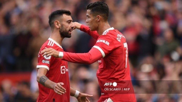 Striker Manchester United Portugal Cristiano Ronaldo (kanan) merayakan dengan gelandang Manchester United Portugis Bruno Fernandes (kiri) setelah mencetak gol kedua mereka selama pertandingan sepak bola Liga Premier Inggris antara Manchester United dan Newcastle di Old Trafford di Manchester, barat laut Inggris, pada 11 September , 2021. \\\\