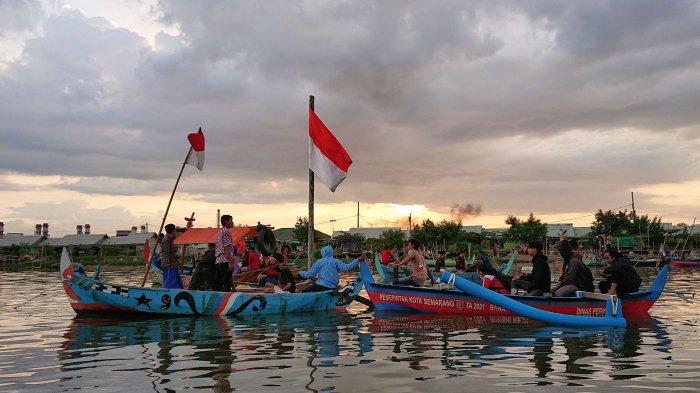 Sejumlah pelajar dan nelayan gelar upacara pengibaran bendera menggunakan perahu di tengah dermaga Kampung Nelayan, Tambakrejo Kota Semarang, Rabu (6/4/2022).