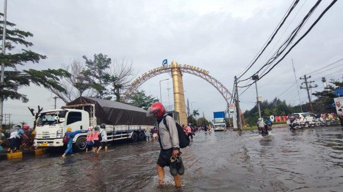 Pekerja pabrik di kawasan Pelabuhan Tanjung Emas terpaksa terjang air rob, Jumat (2/12/2022).