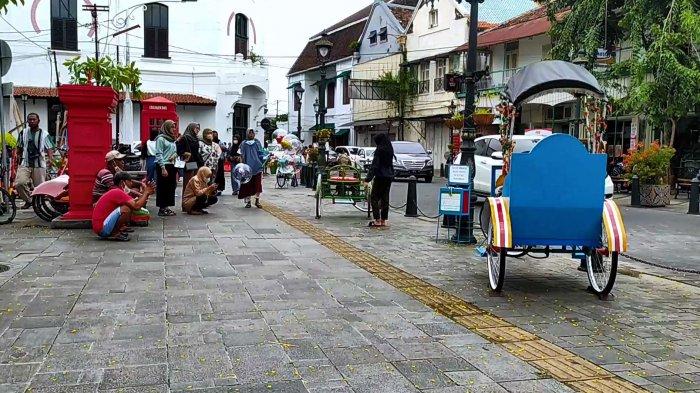 Sejumlah juru foto sukarela tengah memotret pengunjung di kawasan Kota Lama Semarang, Senin (28/2/2022).