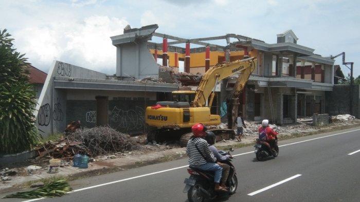 Pengendara sepeda motor melintas di depan rumah yang dibongkar pemiliknya akibat diterjang proyek tol di Jalan Jogja-Solo, Desa Somopuro, Kecamatan Jogonalan, Kabupaten Klaten, Selasa (11/10/2022).