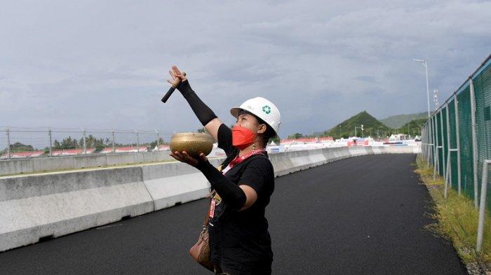 Seorang wanita melakukan ritual tradisional untuk cuaca baik selama sesi latihan untuk MotoGP Grand Prix Indonesia di Sirkuit Internasional Mandalika di Kuta Mandalika di Lombok Tengah pada 18 Maret 2022.