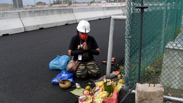 Seorang wanita melakukan ritual tradisional untuk cuaca baik selama sesi latihan untuk MotoGP Grand Prix Indonesia di Sirkuit Internasional Mandalika di Kuta Mandalika di Lombok Tengah pada 18 Maret 2022.