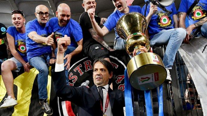 Pelatih Inter Milan Italia Simone Inzaghi memegang trofi merayakan dengan para penggemar setelah Inter memenangkan pertandingan sepak bola final Piala Italia (Coppa Italia) antara Juventus dan Inter pada 12 Mei 2022 di stadion Olimpiade di Roma.