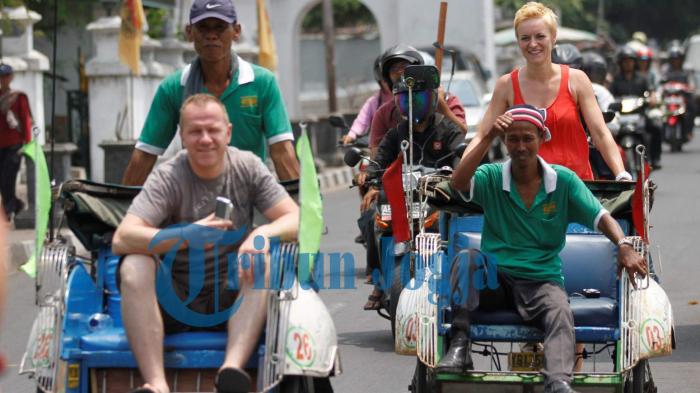 MENGEMUDIKAN BECAK - Seorang wisatawan asing mengemudikan becak saat melintas di kawasan Keraton Yogyakarta, DI Yogyakarta, Jumat(30/9/2011). Selain sebagai alat transportasi tradisional becak juga bisa menjadi daya tarik wisata.