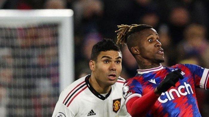 Gelandang Manchester United Casemiro (kiri) menatap bola saat penyerang Crystal Palace Wilfried Zaha menyundulnya pada Liga Inggris antara Crystal Palace vs Man United di Selhurst Park di London pada Rabu 18 Januari atau Kamis 19 Januari 2023 dini hari WIB. Dalam pertandingan itu, Casemiro santai menanggapi selfie seorang fan yang menerobos masuk lapangan.