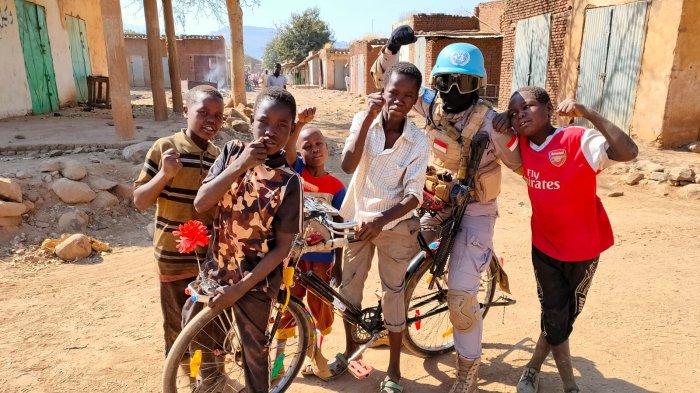 Brigadir Novie bersama anak-anak warga lokasl saat bertugas menjadi prajurit tim perdamaian dunia di Sudan, Afrika Utara.