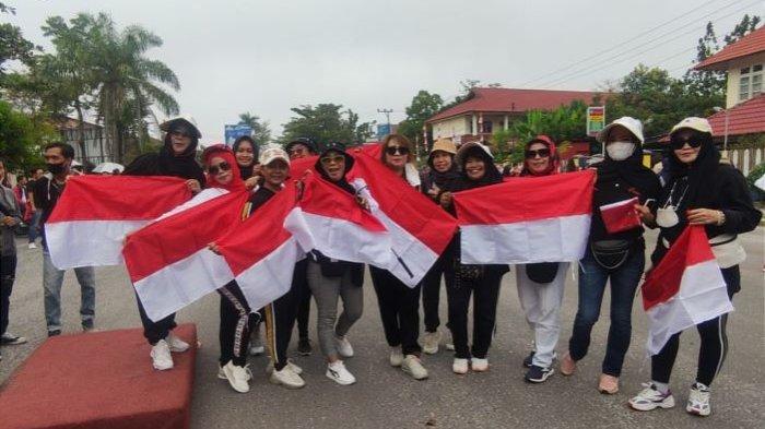 Sejumlah warga tampak bergembira menerima dan memamerkan bendera merah putih yang dibagikan oleh Pemkab Kotim, Jumat (5/8/2022).(Tribunkalteng.com / Devita Maulina)