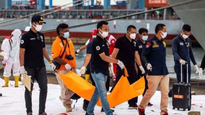Petugas gabungan membawa bagian pesawat Sriwijaya Air SJ 182 rute Jakarta - Pontianak yang jatuh di perairan Pulau Seribu di Dermaga JICT 2, Tanjung Priok, Jakarta Utara, Minggu (10/1/2021). Temuan bagian pesawat selanjutnya akan diperiksa oleh Komite Nasional Keselamatan Transportasi (KNKT) sedangkan potongan tubuh korban diserahkan kepada DVI Polri untuk identifikasi lebih lanjut.(KOMPAS.com/GARRY LOTULUNG)