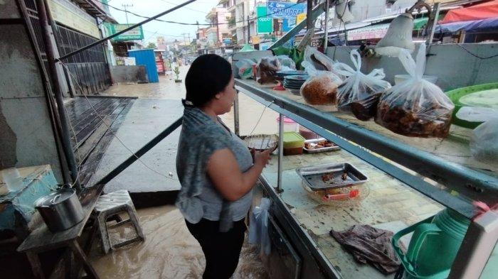 -Seorang warga menjual menu nasi campur dan nasi kuning di Jalan Lambung Magkurat yang tergenang sekira 30 centimeter di Jalan Lambung Mangkurat Samarinda Ilir,ketika hujan melanda sejak pukul 02.00 Wita dinihari hingga pukul 10.00 Wita, Selasa (15/11/2022). TRIBUNKALTIM.CO/NEVRIANTO
