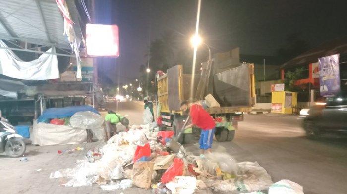 SAMPAH -Petugas kebersihan sedang mengangkut sampah di tepi Jalan Soeharto, Kelurahan Naikoten I, Kota Kupang, Rabi 13 Juli 2022