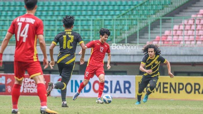 Pemain timnas U-19 Vietnam, Nguyen Bao Long (tengah), dibayangi pilar timnas U-19 Malaysia Muhammad Najmudin Akmal Kamal di Stadion Patriot Candrabhaga, Bekasi, Rabu (13/7/2022).