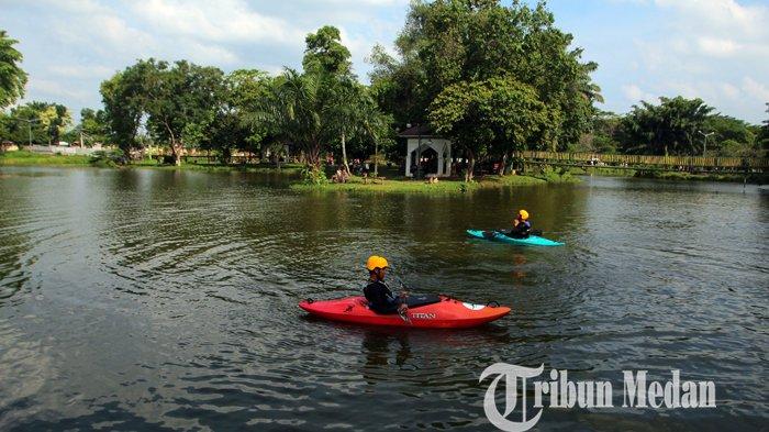 Pengunjung bermain kayak di danau saat menikmati liburan di Taman Cadika Pramuka, Medan, Sabtu (5/6/2021). Taman Cadika merupakan salah satu lokasi ruang terbuka hijau (RTH) yang terbesar di Kota Medan yang menjadi daya tarik masyarakat di masa pandemi.