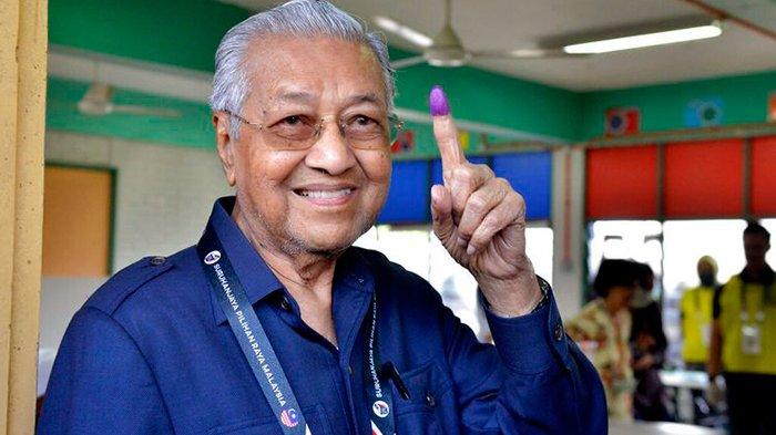 Mantan Perdana Menteri Malaysia dan Menteri Ketua Gerakan Tanah Air (Partai Tanah Air) Mahathir Mohamad menunjukkan jarinya yang bertanda tinta usai mencoblos pemilihan umum di Alor Setar, Kedah, Malaysia, Sabtu, 19 November 2022.