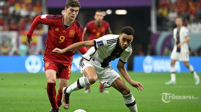 Ragam reaksi hasil imbang 1-1 antara Jerman vs Spanyol pada match kedua Piala Dunia 2022 grup E, Senin (28/11/2022) dini hari WIB. - Gelandang Spanyol Gavi (kiri) menantang gelandang Jerman Jamal Musiala selama pertandingan sepak bola Grup E Piala Dunia 2022 Qatar antara Spanyol dan Jerman di Stadion Al-Bayt di Al Khor, utara Doha pada 27 November 2022. (Photo by Ina Fassbender / AFP)
