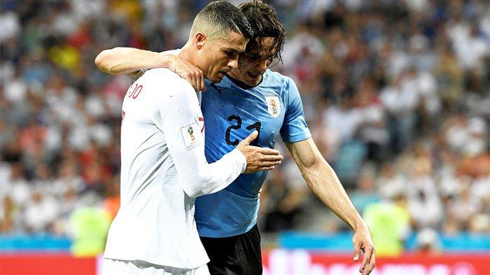 BANTU - Pemain Tim Nasional Portugal Cristiano Ronaldo (kiri) membopong pemain Tim Nasional Uruguay Edinson Cavani yang cedera untuk membantunya berjalan keluar lapangan pada laga perempat final Piala Dunia 2018 yang digelar di Fisht Stadium, Sochi, Rusia, 30 Juni 2018. Portugal akan kembali berhadapan dengan Uruguay di laga kedua Grup H Piala Dunia 2022.