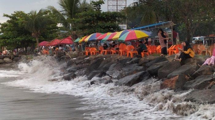 Lapak pedagang di Pantai Puruih Kota Padang Provinsi Sumatera Barat (Sumbar), Senin (10/10/2022). Awan gelap di seberang lautan membuat pedagang cemas karena bisa-bisa ia tidak berjualan jika hujan beranjak ke daratan.