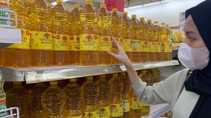 Seorang pembeli tampak melihat sejumlah minyak goreng di salah satu minimarket di Palembang, Rabu (27/4/2022).
