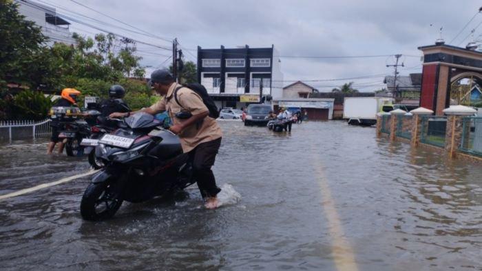 Motor pengendara mogok setelah menerobos banjir di Jalan Sapta Marga Palembang Provinsi Sumatera Selatan, Jumat (9/12/2022).