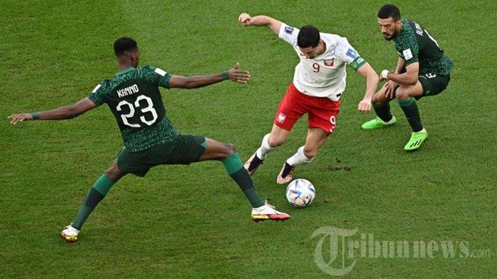 Gelandang Timnas Arab Saudi, #23 Mohamed Kanno (kiri) dan #08 Abdulellah Al-Malki (kanan) mengadang penyerang Timnas Polandia, #09 Robert Lewandowski dalam laga sepak bola Grup C Piala Dunia 2022 Qatar antara Polandia melawan Arab Saudi di Education City Stadium, di Al-Rayyan, barat Doha, Qatar, Sabtu (26/11/2022).