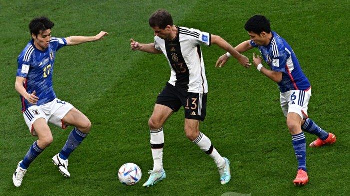 Pemain depan Timnas Jerman, #13 Thomas Mueller (tengah) berebut bola dengan gelandang Timnas Jepang, #17 Ao Tanaka (kiri) dan gelandang Timnas Jepang, #06 Wataru Endo dalam laga sepak bola Grup E Piala Dunia 2022 Qatar antara Jerman melawan Jepang di Stadion Internasional Khalifa, di Doha, Qatar, Rabu (23/11/2022) waktu setempat.