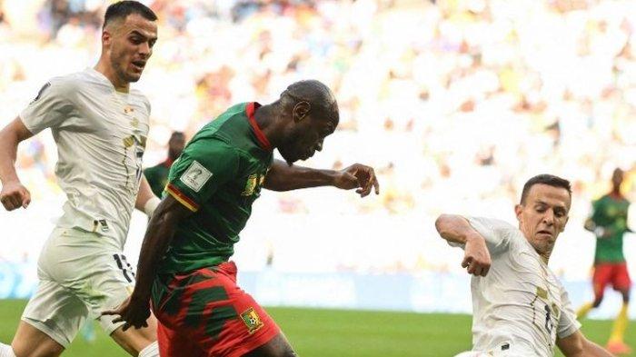 Penyerang Kamerun Christian Bassogog (hijau) berebut bola dengan gelandang Serbia Nemanja Maksimovic pada laga Grup G Piala Dunia 2022 Qatar antara Kamerun vs Serbia di Stadion Al-Janoub di Al-Wakrah, selatan Doha pada Senin 28 November 2022.