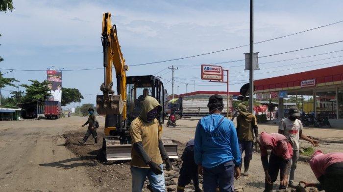 Petugas dari Dinas Pekerjaan Umum dan Penataan Ruang (DPUPR) Kota Tegal melakukan perbaikan dengan menambal jalan berlubang di Jalan Mataram, Kota Tegal, Rabu (5/1/2022).