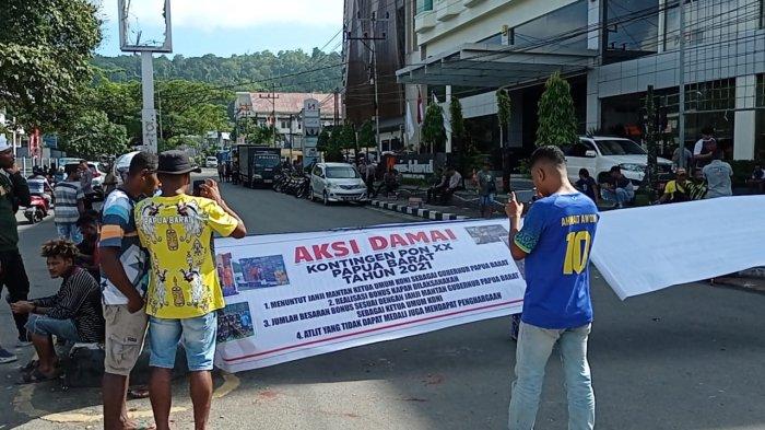 PALANG JALAN - Sejumlah atlet Pekan Olahraga Nasional atau PON XX Papua, asal Papua Barat melakukan aksi pemasangan jalan Yos Sudarso, Distrik Manokwari Barat, Kabupaten Manokwari, Papua Barat, Rabu (30/11/2022).