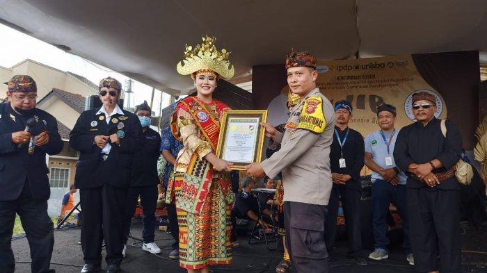 Pembina Pemuda Kolaborasi Desa dan merupakan Bhabinkamtibnas Desa Cinunuk, Aipda Heri Maryadi (kanan), mendapatkan piagam Original Rekor Indonesia (ORI) usai sukses menggelar