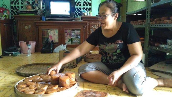 Maya Isyanawati, generasi ketiga pemilik bisnis kue keranjang Dua Naga Mas menata kue keranjang yang akan dijual di Kelurahan Sudiroprajan, Jebres, Solo, Selasa (29/1/2019).