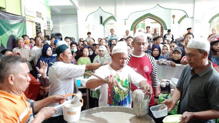 Panitia Masjid Darussalam saat memasukkan bubur samin ke wadah yang dibawa oleh warga, Senin (6/5/2019)
