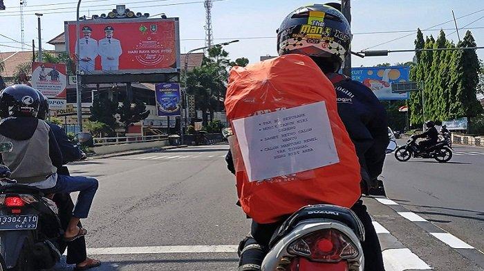 Pemudik bermotor menempelkan kata-kata unik di punggungnya saat melintas di Jalan Raya Solo-Semarang dan Jalan Ahmad Yani, Solo kawasan Kleco, Solo, Sabtu (1/6/2019)