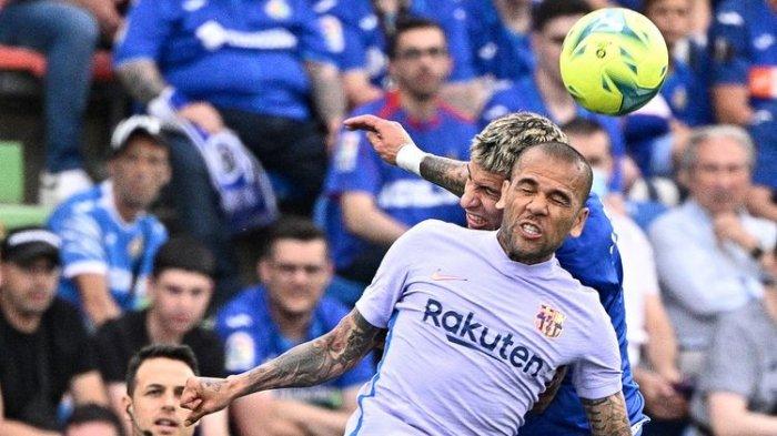 Bek Barcelona Dani Alves (depan) melakukan duel udara dengan pemain Getafe Mathias Olivera dalam laga lanjutan Liga Spanyol musim 2021-2022 di Stadion Alfonso Perez, Getafe, Spanyol, pada Senin (16/5/2022) dini hari WIB.