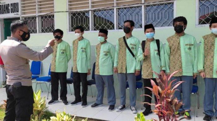 Bhabinkamtibmas Polsek Kota Mamuju Bripka Lexy M saat memberikan edukasi kepada siswa di MAN 1 Mamuju, Jl Soekarno Hatta, Kelurahan Karema, Kecamatan Mamuju, Mamuju, Sulawesi Barat (Sulbar), Kamis (9/9/2021).