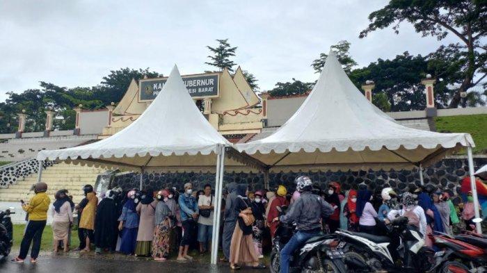 BERBURU MINYAK GORENG - Hujan deras tak menghalangi emak-emak di Kabupaten Mamuju berburu minyak goreng murah di depan kantor Gubernur Sulbar, Jumat (25/2/2022). Mereka menunggu sejak pagi demi mendapatkan minyak goreng kemasan jerigen lima liter yang disediakan Pemprov Sulbar.